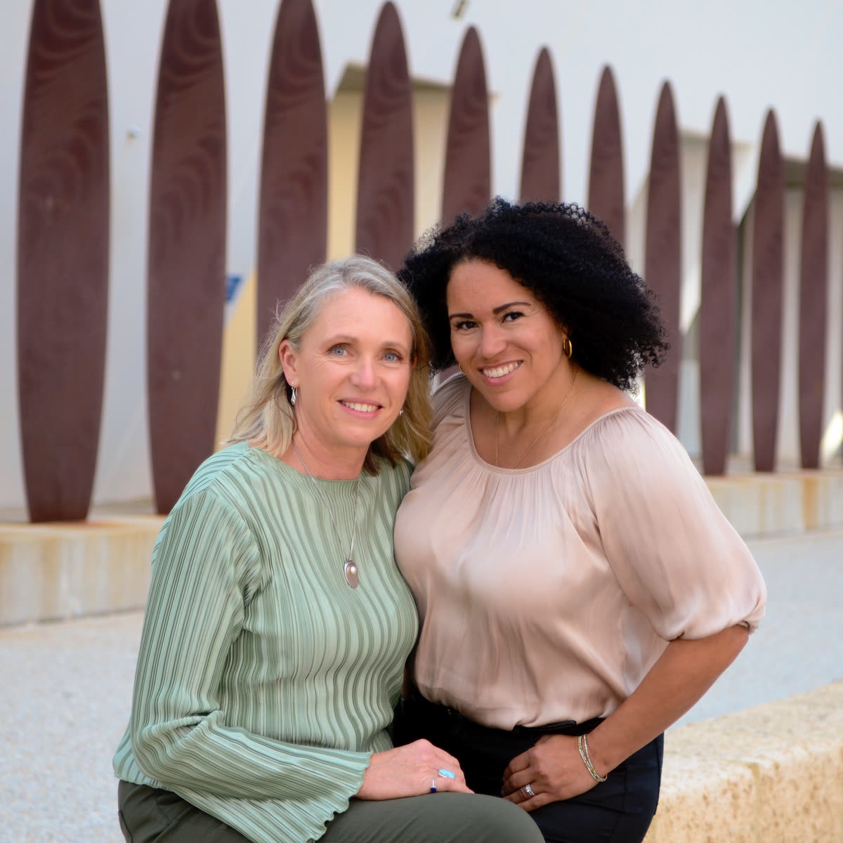 Jodie and Laila seated together outdoors
